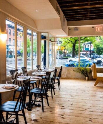 A cozy restaurant interior featuring neatly arranged tables and chairs for dining. - Hausion