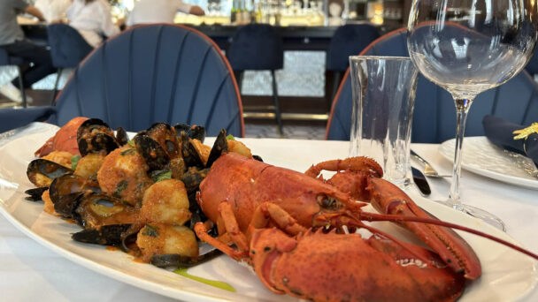 A beautifully plated lobster and mussels, showcasing fresh seafood at a fine dining restaurant. - Hausion