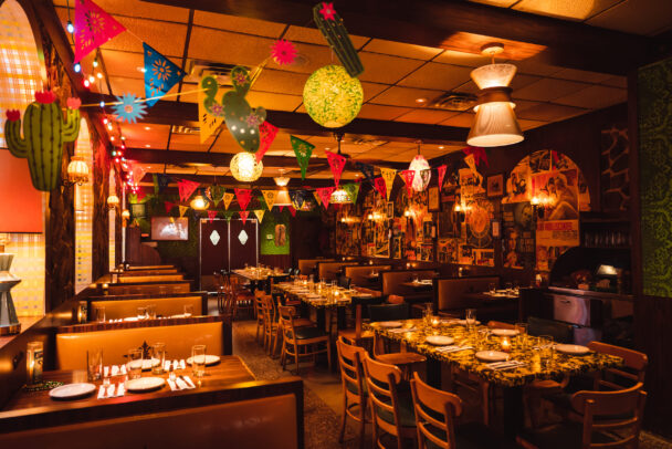 A vibrant restaurant filled with colorful decorations and inviting tables, creating a lively dining atmosphere. - Hausion