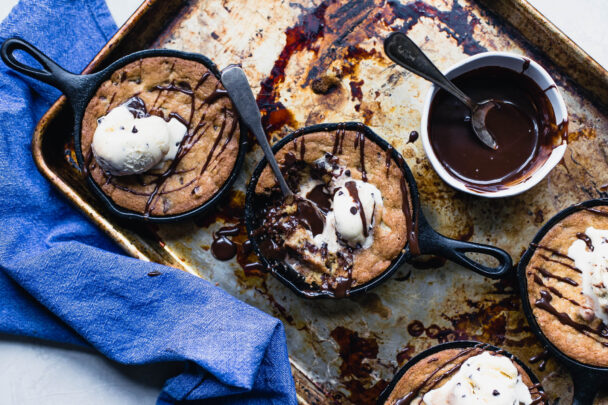 A tempting skillet of chocolate chip cookies, warm and gooey, inviting you to indulge in a sweet, comforting treat. - Hausion