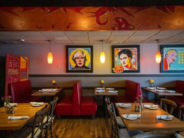 Welcoming restaurant showcasing red booths and decorative paintings, perfect for a comfortable and enjoyable dining experience. - Hausion