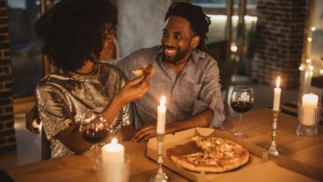 A young couple sharing a romantic pizza dinner.